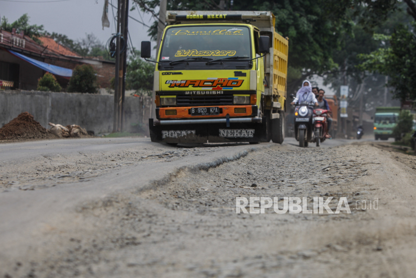 Truk melintasi jalan yang rusak di Jalan Sudamanik, Kecamatan Parunganjang, Kabupaten Bogor, Jawa Barat, Senin (20/11/2023).