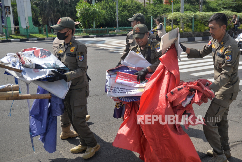 Petugas Satpol PP mencopot Alat Peraga Kampanye (APK) yang masih terpasang di Kawasan Jalan Margonda, Depok, Jawa Barat, Ahad (11/2/2024). Pencopotan dan pembersihan APK tersebut dilakukan karena telah memasuki masa tenang menjelang pelaksanaan Pemilu 2024 pada 14 Februari mendatang.