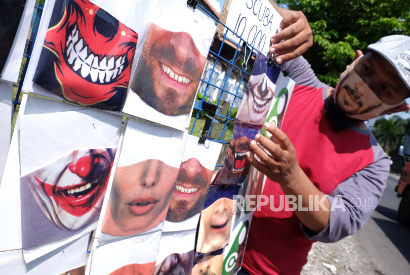 Pedagang menata masker karakter wajah berbahan kain di Solo, Jawa Tengah, Senin (8/6/2020). Pedagang setempat mengaku masker karakter wajah yang dijual seharga Rp10 ribu per helai tersebut banyak diminati warga sebagai upaya pencegahan penyebaran COVID-19