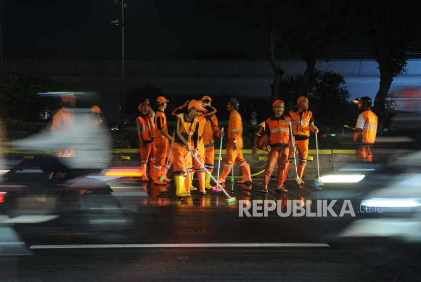 Petugas PPSU membersihkan separator Transjakarta di Jl MT Haryono, Jakarta Selatan, Rabu (30/8/2023) malam. (Ilustrasi)