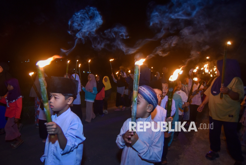 Sejumlah anak mengikuti pawai obor saat malam takbiran di Nagari Sungai Batang, Agam, Sumatera Barat, Kamis (19/3/2026). Warga terdampak banjir bandang November 2025 di daerah itu bersukacita menyambut Idul Fitri 1447 hijriah dengan menggelar berbagai atraksi seperti arak-arakan pawai obor dan gandang tambua tansa. 