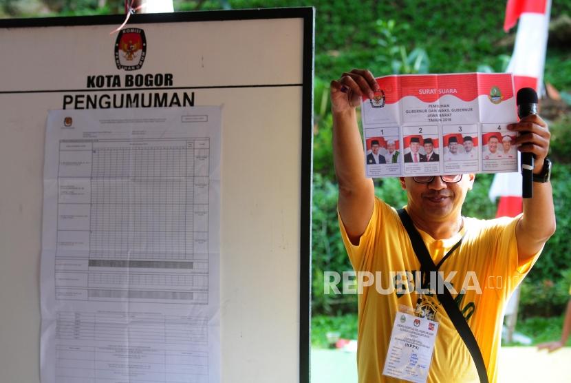 Petugas memperlihatkan surat suara yang telah dicoblos saat penghitungan suara Pilkada serentak 2018 