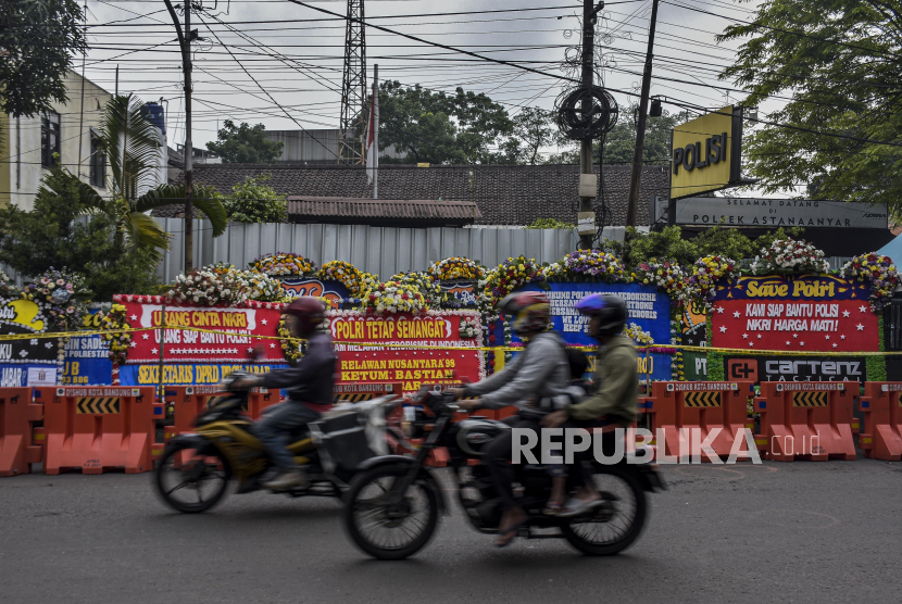 Pengendara melintas di depan deretan karangan bunga pascaledakan bom bunuh diri di Mapolsek Astanaanyar, Jalan Astanaanyar, Kota Bandung, Jumat (9/12/2022). 