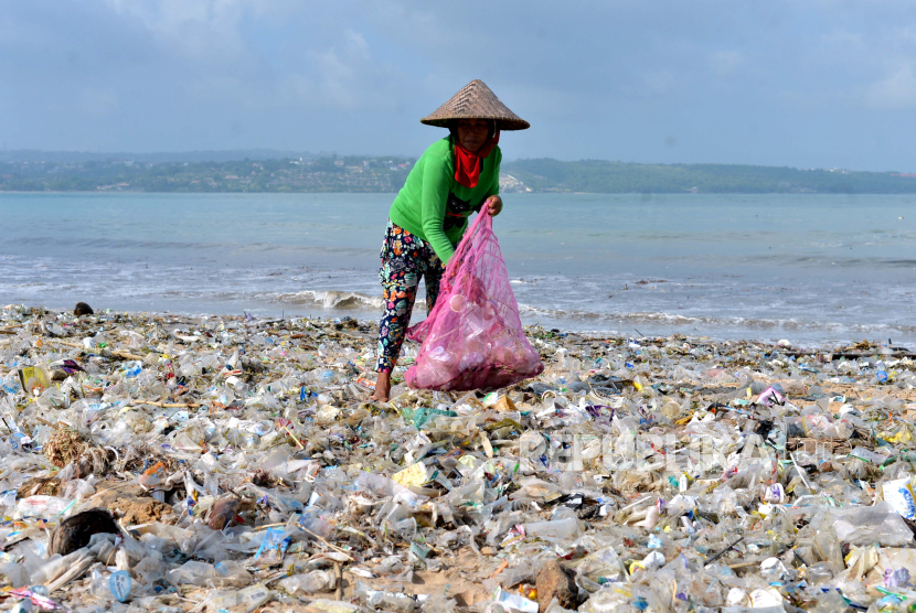 Warga memungut sampah plastik di kawasan Pantai Kedonganan, Badung, Bali.
