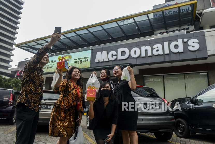 Pengunjung berfoto bersama usai membeli makanan di gerai makanan cepat saji McDonald
