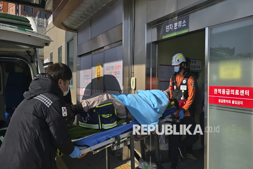 Seorang korban yang diselamatkan dari kecelakaan pesawat  Jeju Air 7C2216 diangkut ke rumah sakit di Mokpo, Korea Selatan, Ahad (29/12/2024). Pesawat Jeju Air 7C2216 yang membawa 175 penumpang dan enam kru dalam penerbangan dari Bangkok, Thailand jatuh terbakar dan meledak setelah mendarat dan kemudian menghantam tembok pembatas di bandara Internasional Muan. Data sementara 85 orang tewas dalam peristiwa itu.