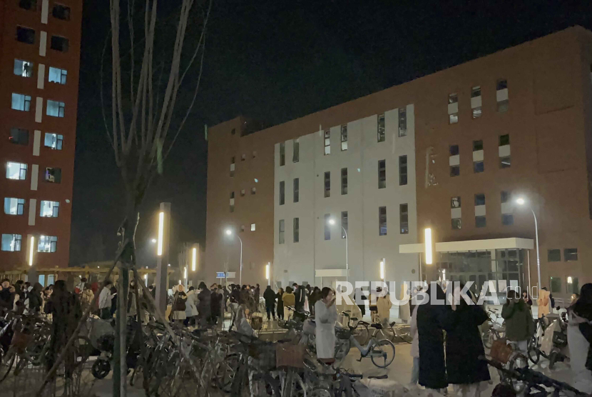 Para mahasiswa berkumpul di luar ruangan setelah dievakuasi dari asrama mereka di kampus Universitas Lanzhou Yuzhong di Lanzhou, barat laut Cina. 