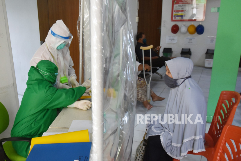 Sejumlah tenaga kesehatan (Nakes) mengenakan baju pelindung diri dan melayani pasien dari tirai plastik pembatas di sebuah Puskesmas di Kota Pekanbaru, Riau, Kamis (24/9). (ilustrasi) 