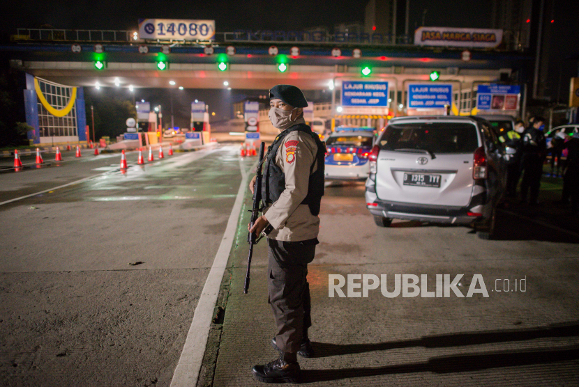 Petugas kepolisian berjaga di area Gerbang Tol Cikarang Barat, Bekasi, Jawa Barat, Sabtu (23/5) dini hari. Jasa Marga mencatat sebanyak 30 ribu kendaraan diminta putarbalik di Cikarang Barat.