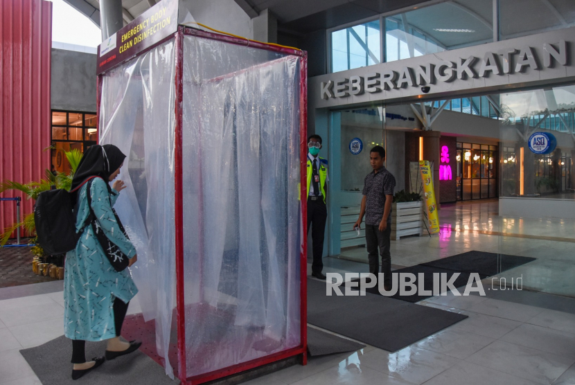 Penumpang memasuki bilik disinfektan yang terpasang di pintu keberangkatan Bandara Internasional Lombok (BIL) di Praya, Lombok Tengah, NTB, Jumat (27/3/2020). PT Angkasa Pura (AP) I (Persero) memperpanjang masa oerasional di 15 bandara yang dikelolanya. 