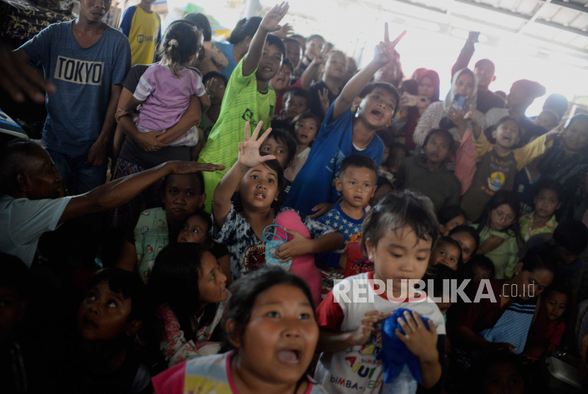 Anak-anak korban kebakaran menyaksikan penampilan badut dari Aki Badut Indonesia di salah satu posko pengungsian di kawasan Rawa Badak, Jakarta, Rabu (8/3/2023). Kegiatan tersebut bertujuan untuk memberikan hiburan dan trauma healing bagi anak-anak korban kebakaran depo Pertamina Plumpang yang terjadi beberapa hari lalu.