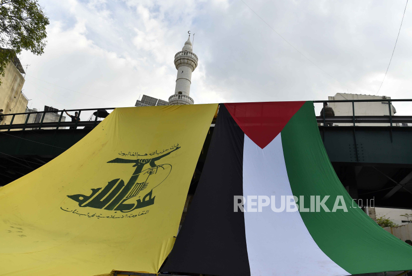 Bendera Hizbullah dan Palestina dibentangkan, tanda bela Palestina dan mengecam Israel.
