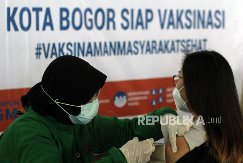 Petugas kesehatan menyuntikan vaksin COVID-19 ke pedagang pasar di area parkir Blok F, Pasar Kebon Kembang, Kota Bogor, Jawa Barat, Kamis (18/3/2021). Sebanyak 1.800 pedagang pasar di Kota Bogor mulai mengikuti vaksinasi COVID-19 tahap kedua dengan target sasaran penerima vaksin lebih dari 10 ribu pedagang sebagai upaya untuk memulihkan kondisi di sektor ekonomi. 