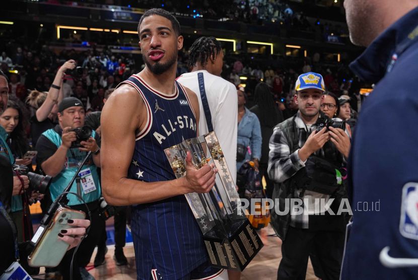 Indiana Pacers guard Tyrese Haliburton (0) carries the Championship trophy after the East defeated the West 211-186 in the NBA All-Star basketball game in Indianapolis, Sunday, Feb. 18, 2024.  