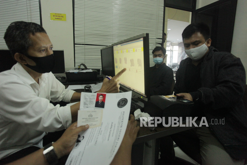 Petugas melayani pemohon penerbitan Surat Keterangan Catatan Kepolisian (SKCK) di Polres Metro Jakarta Selatan, Jakarta. Menurut data kepolisian setempat, pembuatan pemohonan penerbitan SKCK meningkat antara 200 hingga 300 orang per harinya, dengan 50 persennya terkait keperluan pendaftaran Calon Pegawai Negeri Sipil (CPNS) 