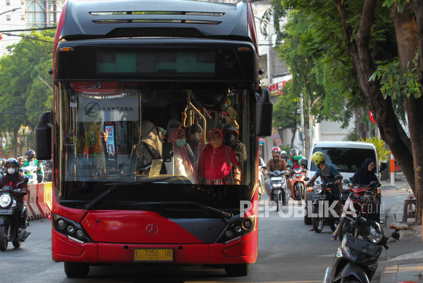 Bus Suroboyo berisi penumpang melintas di Jalan Basuki Rahmat. Pemkot Surabaya menyediakan layanan transportasi gratis bagi masyarakat yang menonton Piala Dunia U-17 di Gelora Bung Tomo.