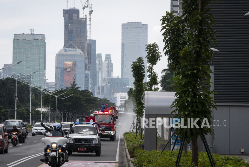 Petugas pemadam kebakaran menyemprotkan cairan disinfektan di Jalan Jenderal Sudirman, Jakarta, Jumat (3/4/2020). WHO meminta masyarakat dilibatkan dalam menghadapi pandemi Covid-19.