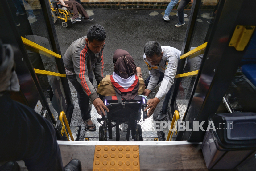 Petugas membantu menaikan siswa kedalam bus sekolah khusus disabilitas (ilustrasi).   