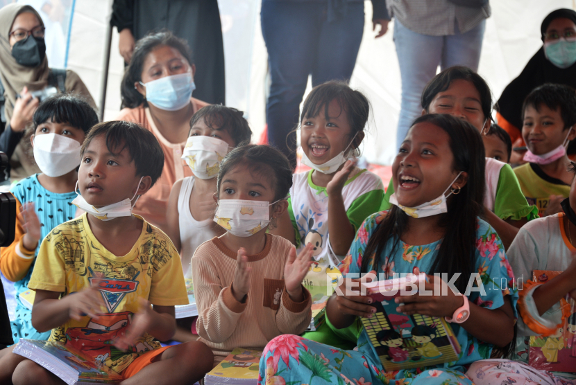 Anak-anak menyaksikan aksi Komunitas Aku Badut Indonesia (ABI) di Posko Pengungsi erupsi Gunung Semeru di Lapangan Penanggal, Kabupaten Lumajang, Jawa Timur. 