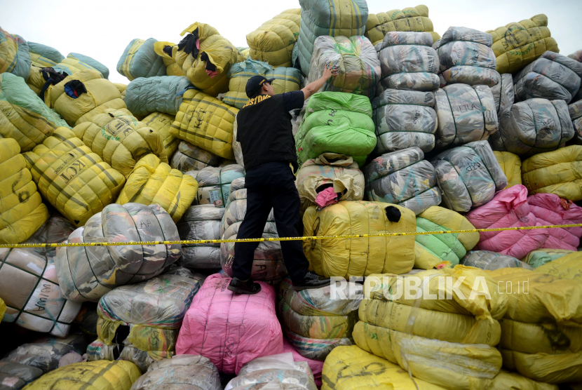 Petugas Bea Cukai memeriksa pakaian bekas saat rilis dan pemusnahan barang bukti hasil operasi penindakan Balepressed (Pakaian Bekas Ilegal) di Tempat Penimbunan Pabean (TPP) Bea Cukai Cikarang, Jawa Barat, Selasa (28/3/2023). 