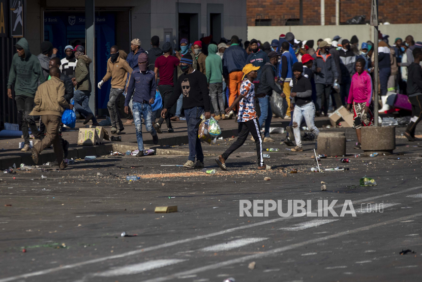 Penjarah membawa barang-barang di Pusat Perbelanjaan Letsoho di Katlehong, sebelah timur Johannesburg, Afrika Selatan, Senin, 12 Juli 2021. Polisi mengatakan enam orang tewas dan lebih dari 200 telah ditangkap di tengah meningkatnya kekerasan selama kerusuhan yang pecah setelah pemenjaraan South Mantan Presiden Afrika Jacob Zuma.