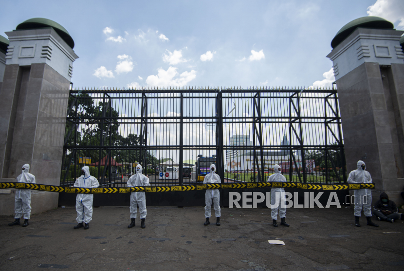 Polisi mengenakan masker dan pakaian hazmat saat mengamankan unjuk rasa penolakan buruh terhadap RUU Ciptaker di depan Gedung DPR Jakarta, pekan lalu. DPR rencananya akan mengesahkan RUU Cipta Kerja menjadi undang-undang pada hari ini. (ilustrasi)