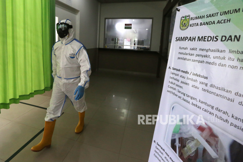 Petugas medis Rumah Sakit Umum Daerah (RSUD) Meuraxa yang menggunakan Alat Pelindung Diri (APD) untuk penanganan pasien yang diduga terinfeksi virus Corona (COVID-19) melintas di depan ruang isolasi sementara di Banda Aceh, Aceh, Rabu (18/3/2020).(Antara/Irwansyah Putra)