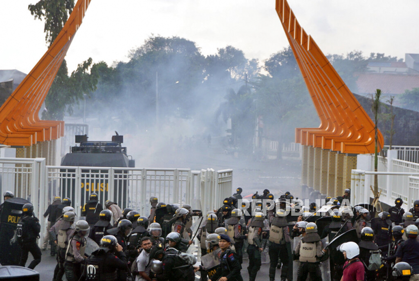  Polisi anti huru hara menembakkan gas air mata untuk membubarkan oknum suporter PSIS Semarang  di luar Stadion Jatidiri di Semarang, Jawa Tengah, Jumat (17/2/2023).