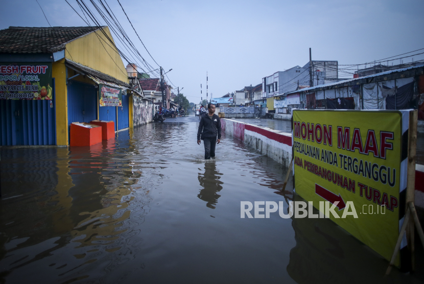 Warga melintasi banjir yang merendam Perumahan Pondok Maharta, Pondok Kacang, Tangerang Selatan, Banten, Sabtu (5/11/2022). Banjir yang merendam ratusan rumah warga tersebut terjadi akibat belum rampungnya perbaikan tanggul yang jebol.