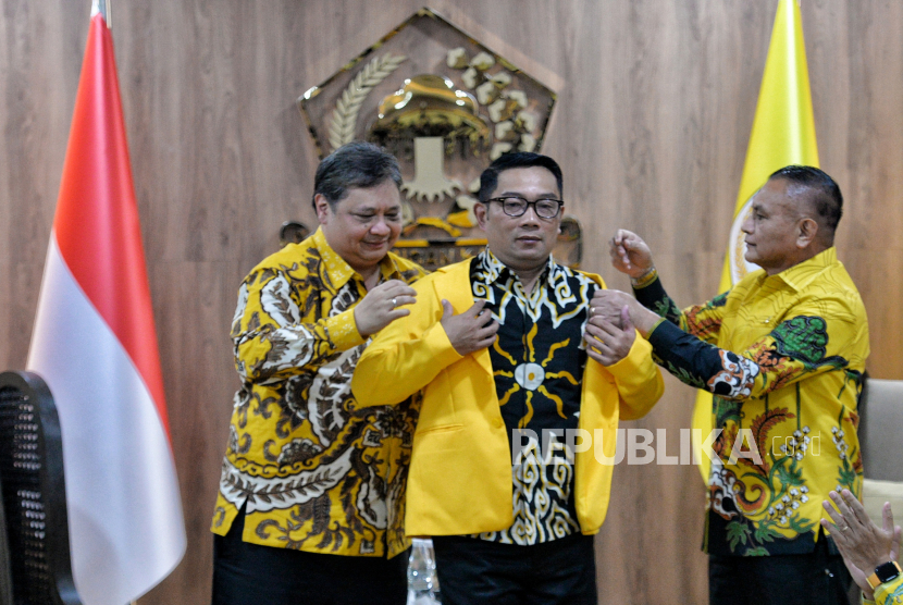 Ketua Umum Partai Golkar, Airlangga Hartarto (kiri) memakaikan jas kuning kepada Gubernur Jawa Barat Ridwan Kamil (kedua kanan) saat melakukan pertemuan politik di kantor DPP Partai Golkar, Jakarta Barat, Rabu (18/1/2023). Ridwan Kamil atau Kang Emil resmi bergabung dengan Partai Golkar setelah Ketua Umum Airlangga Hartarto menyerahkan kartu tanda anggota (KTA) dan jas warna kuning Partai Golkar.