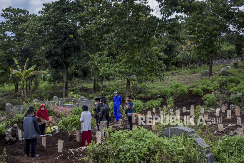 Sejumlah keluarga dan kerabat memanjatkan doa usai prosesi pemakaman dengan protokol Covid-19 di TPU Cikadut, Jalan Cikadut, Mandalajati, Kota Bandung, Selasa (9/3). 