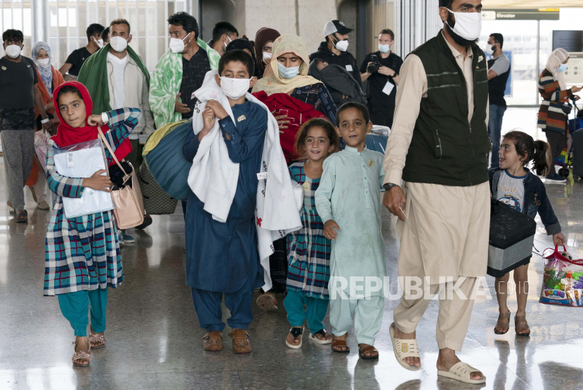 Keluarga dievakuasi dari Kabul, Afghanistan, berjalan melalui terminal sebelum naik bus setelah mereka tiba di Bandara Internasional Washington Dulles, di Chantilly, Va, pada Kamis, 26 Agustus 2021.