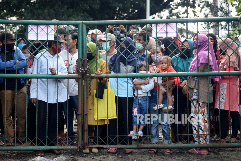 Warga antre sembako di luar gedung Baznas Kabupaten Bogor, Cibinong, Jabar, Senin (20/4). Ratusan warga rela mengantre dan tidak mepedulikan physical distancing untuk mendapatkan 5 kg beras dan 10 bungkus mie instan