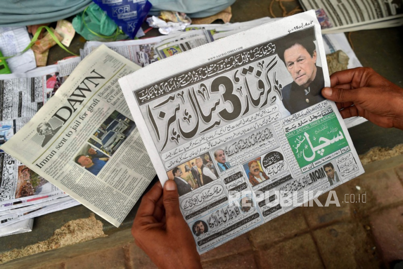 Masyarakat membaca berita halaman depan penangkapan mantan Perdana Menteri dan Ketua partai oposisi Pakistan Tehreek-e-Insaf (PTI), Imran Khan, di Karachi, Pakistan, (6/8/2023).