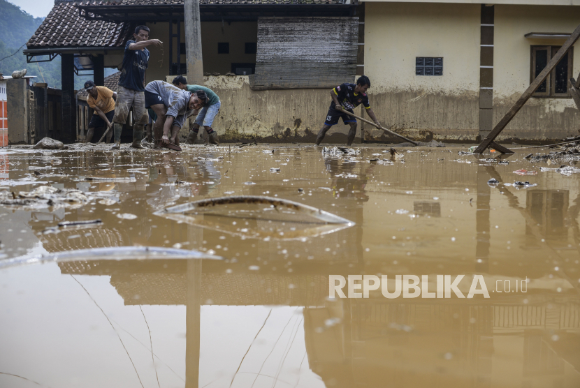 Sejumlah warga membersihkan jalan yang tertutup lumpur di Desa Purasari, Kecamatan Leuwiliang, Kabupaten Bogor, Jawa Barat, Kamis (23/6/2022).