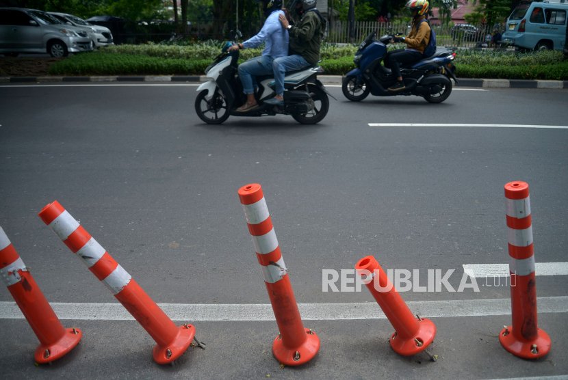 Sejumlah pengendara melintas di samping stick cone pembatas jalur sepeda yang rusak di Kawasan Jalan Penjernihan I, Jakarta. Pemprov DKI menggelontorkan anggaran Rp7,5 miliar untuk optimalisasi jalur sepeda.