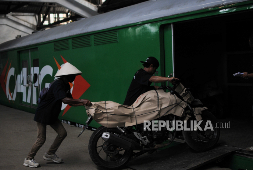 Petugas memasukan sepeda motor yang akan dikirim ke daerah asal pemudik ke dalam kereta di Stasiun Jakarta Gudang KAI Logistik, Kampung Bandan, Jakarta, Jumat (14/4/2023). 