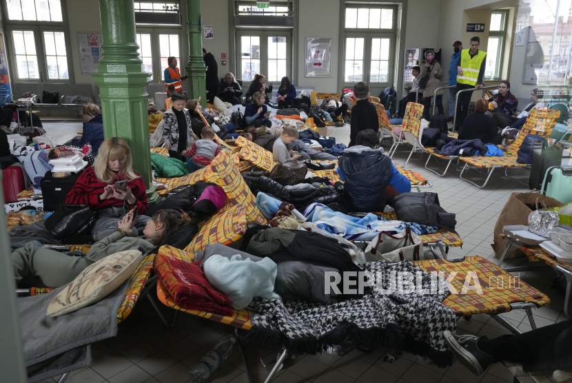 Pengungsi dari Ukraina beristirahat setelah tiba di stasiun kereta api di Przemysl, Polandia, Ahad, 27 Februari 2022. 