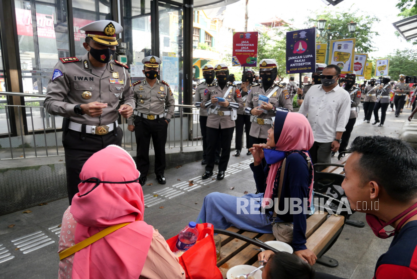 Polisi memberikan penyuluhan kepada  warga saat kampanye penggunaan masker oleh Polda DIY di kawasan Malioboro Yogyakarta, Kamis (10/9). Selain kampanye penggunaan masker juga pembagian masker gratis. Hal ini salah satu upaya pengendalian Covid-19 yang akhir-akhir ini kurvanya meningkat.