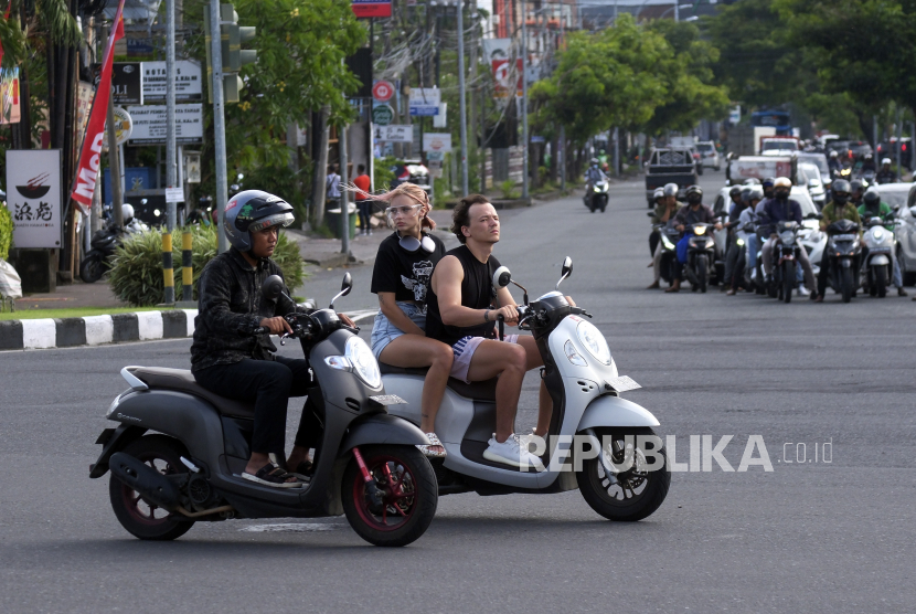 Sejumlah turis asing mengendarai sepeda motor tanpa mengenakan helm di Jalan Sunset Road, Kuta, Badung, Bali, Selasa (28/2/2023). Sejumlah pemilik rental motor di Bali menyatakan risau dan tidak setuju dengan rencana aturan gubernur Bali yang melarang wisatawan mancanegara untuk menyewa motor. (ilustrasi)