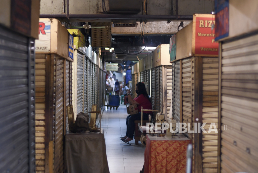 Seorang warga duduk di antara pertokoan yang tutup di Pasar Baru, Jakarta, Jumat (3/4/2020). Sebagian besar pertokoan menutup usahanya sesuai edaran pemerintah untuk mengantisipasi penyebaran virus corona atau COVID-19