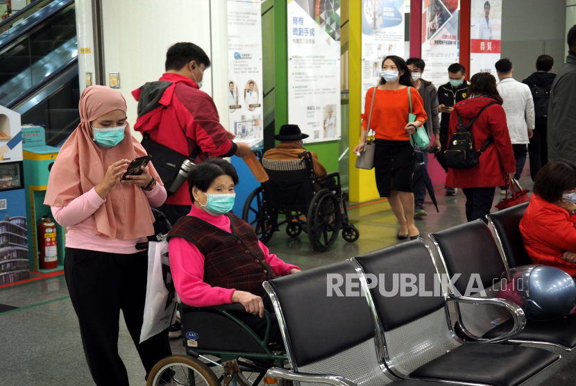 Seorang pembantu Asia Tenggara (kiri) membawa seorang perempuan Taiwan yang terikat kursi roda (kanan) ke rumah sakit di Taipei, Taiwan, 04 Desember 2020. Taiwan mengatakan akan menangguhkan impor pekerja dan pembantu yang ditangani oleh 14 agen perekrutan Indonesia dari 04 hingga 17 Desember. tingkat Covid-19 yang tinggi dan 