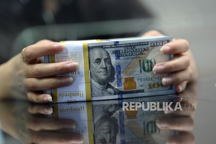 Karyawan menghitung mata uang dolar AS di gerai penukaran mata uang asing VIP (Valuta Inti Prima) Money Changer, Jakarta, Selasa (17/10/2023). 