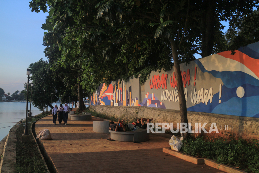 Sejumlah anak sekolah berjalan di samping tembok yang dilukis mural di kawasan objek wisata (ilustrasi) 