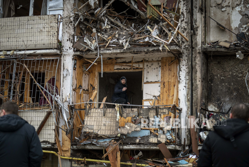  Seorang pria memeriksa kerusakan di sebuah gedung setelah serangan roket di kota Kyiv, Ukraina, Jumat, 25 Februari 2022.