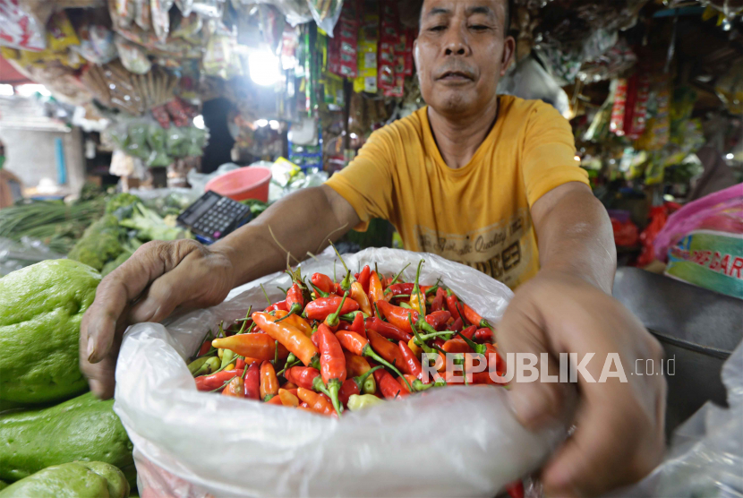 Seorang pedagang memegang sekantong cabai merah di pasar tradisional di Jakarta, Indonesia, 01 Agustus 2022. Badan Pangan Nasional/National Food Agency (NFA) akan memproteksi komoditas pangan yang surplus agar tidak dilakukan impor dalam rangka menghasilkan harga yang wajar. 