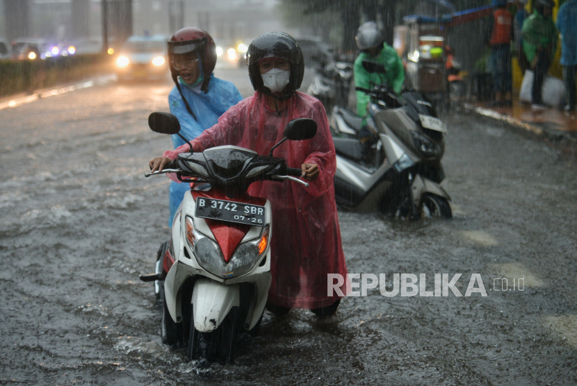 Pengendara mendorong kendaraannya yang mogok akibat terendam genangan air yang menutupi ruas jalan H.R Rasuna Said, Jakarta, Rabu (3/4/2024). Genangan tersebut disebabkan oleh intensitas hujan yang tinggi serta aliran drainase yang meluap sehingga menyebabkam lalu lintas tersendat.