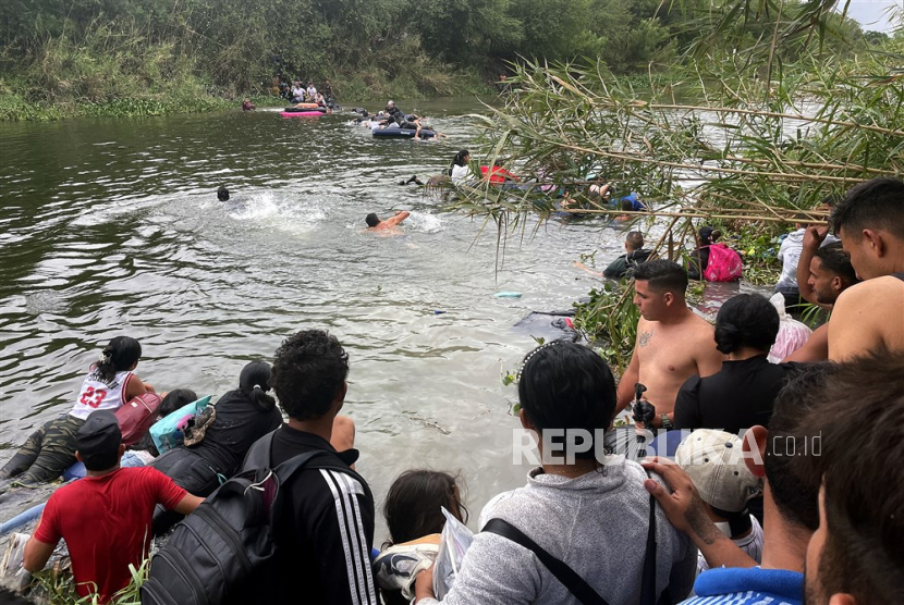  Sekelompok migran berkumpul untuk menyeberangi sungai Rio Grande, di Matamoros, Meksiko, menuju perbatasan Amerika Serikat  pada 24/ April 2023. 