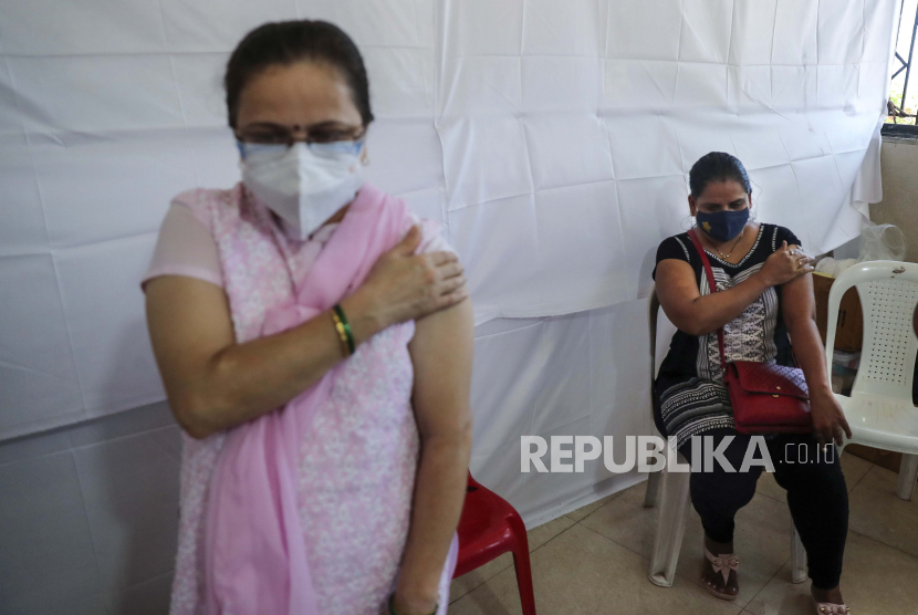 Wanita memegang tangan mereka setelah menerima vaksin Covishield melawan virus corona di pusat vaksinasi di Mumbai, India, Ahad (4/7). Menggunakan vaksin yang berbeda untuk dosis pertama dan kedua alias mencampur vaksin dinilai sebagai tindakan yang berisiko. 