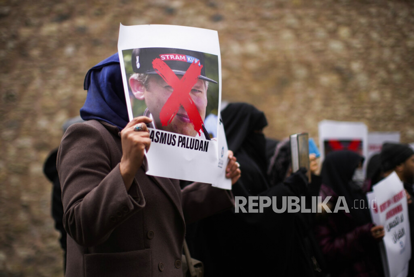  Seorang perempuan memegang foto aktivis sayap kanan Rasmus Paludan saat protes di luar konsulat Swedia di Istanbul, Turki, Sabtu, 28 Januari 2023. 